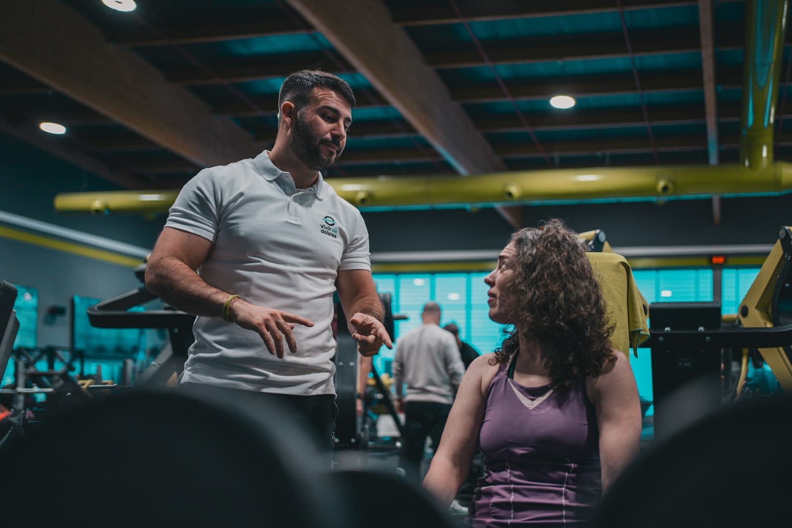 A trainer talking with a client in a gym