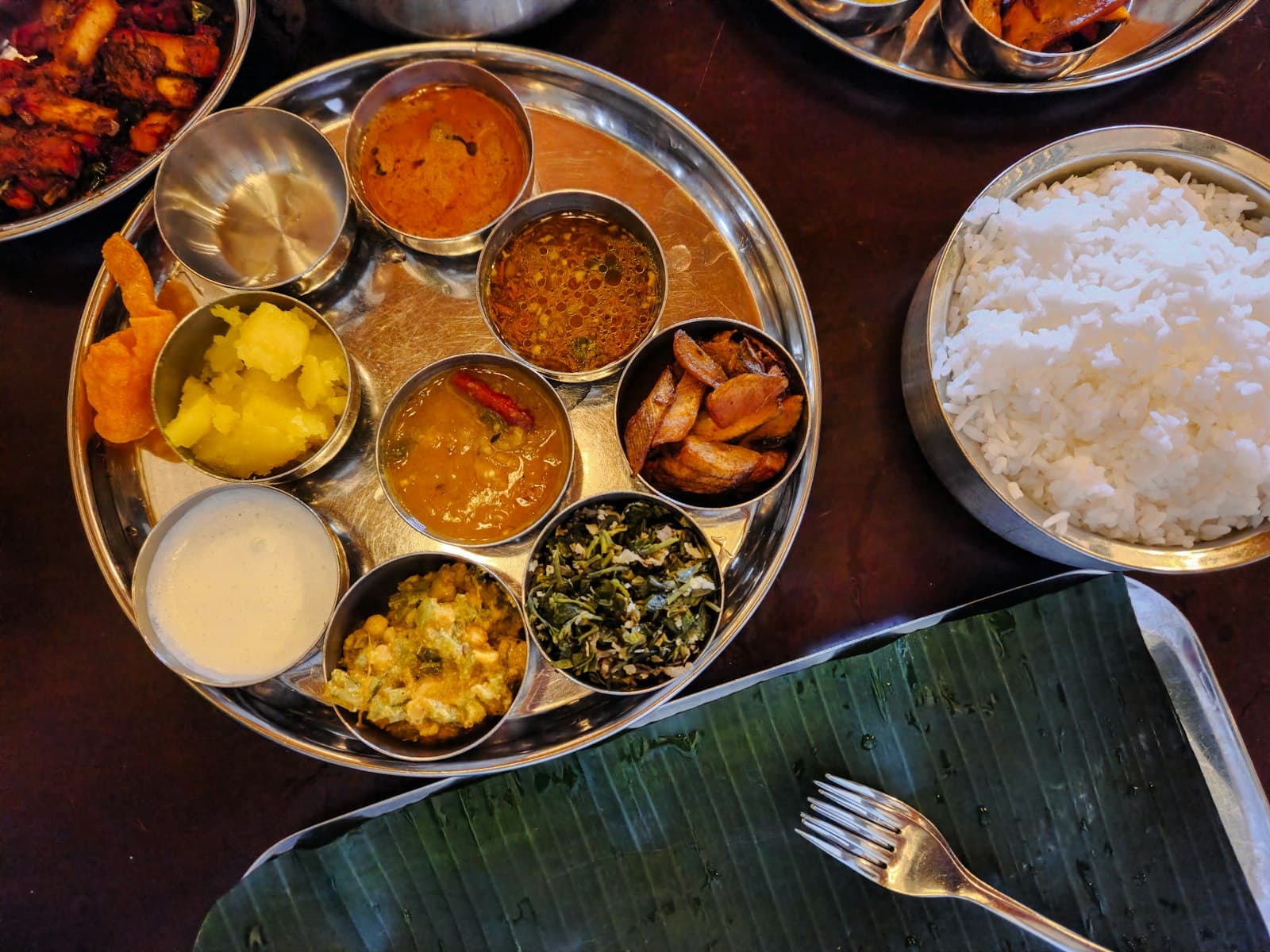 A thali seen from above: rice and several curries and sides in small bowls