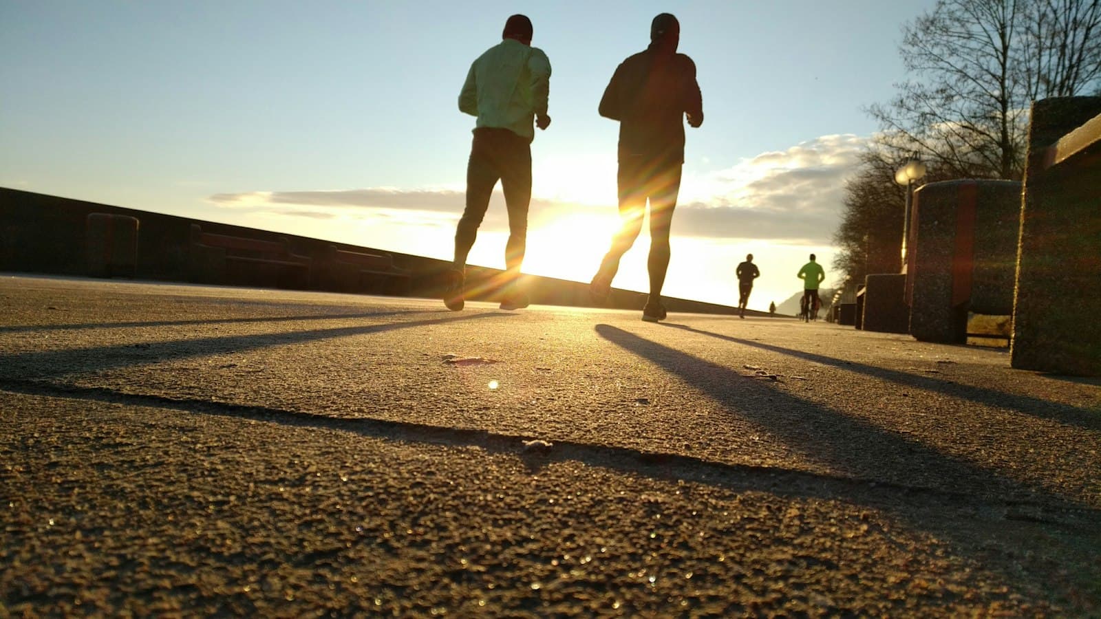 Two people running along a path at sunset